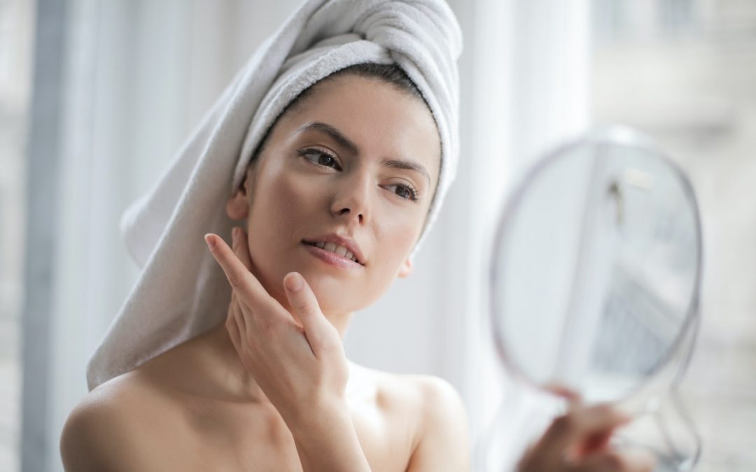 Radiofrequenza estetica: donna si specchia accarezzandosi la pelle